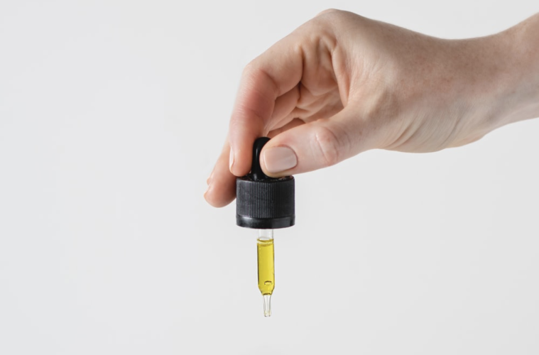 Yellow liquid THC in a dropper vial, white background