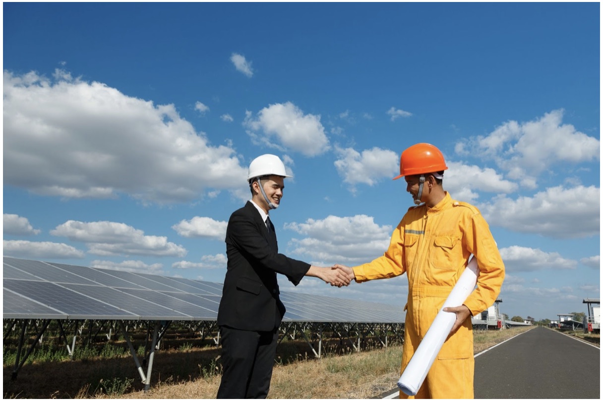 engineer and businessman next to solar panels